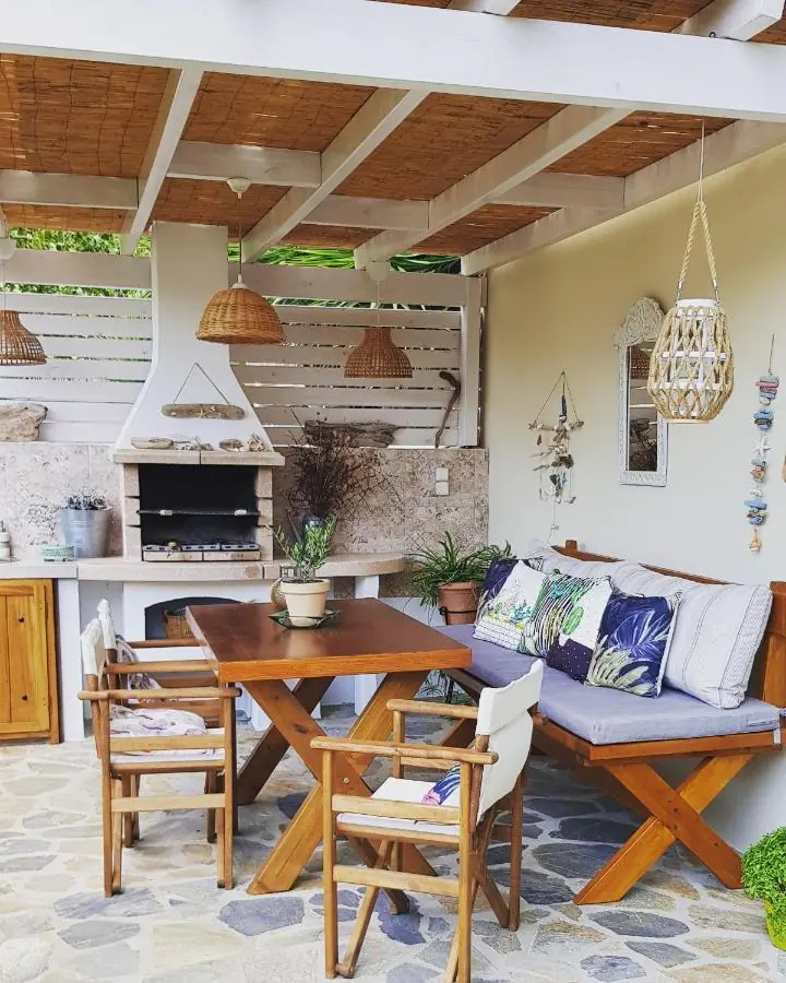 Barbecue, dining table and cushioned bench under the pergola